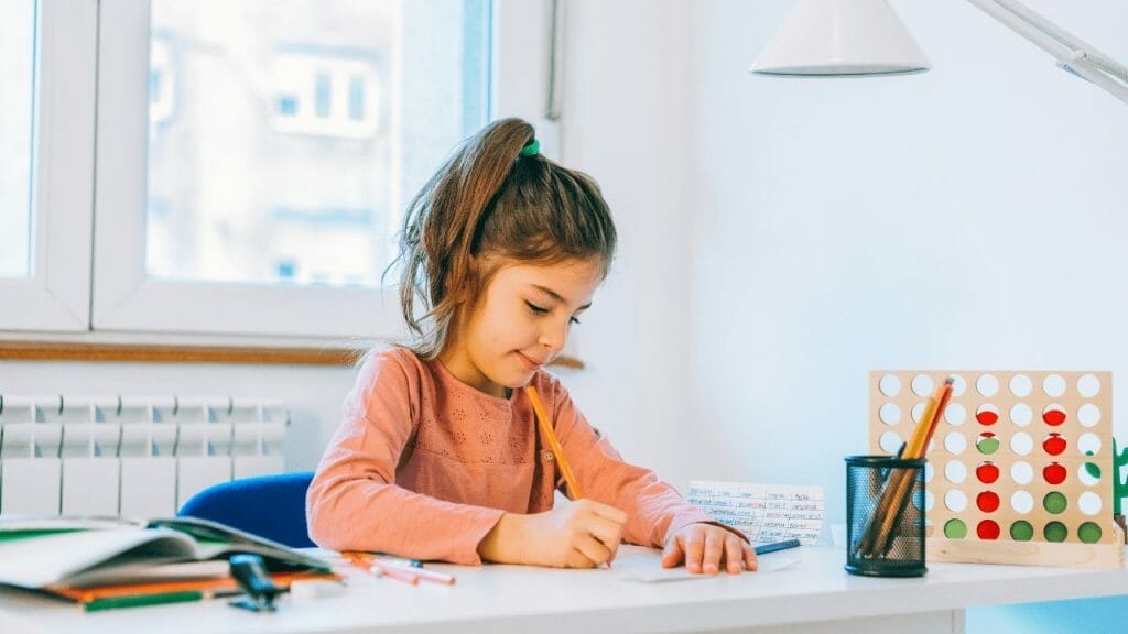 Girl does her homework sitting in a desk