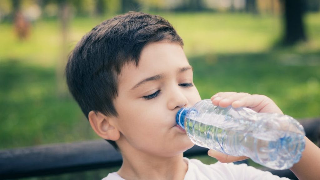 A boy drinks water during a school trip
