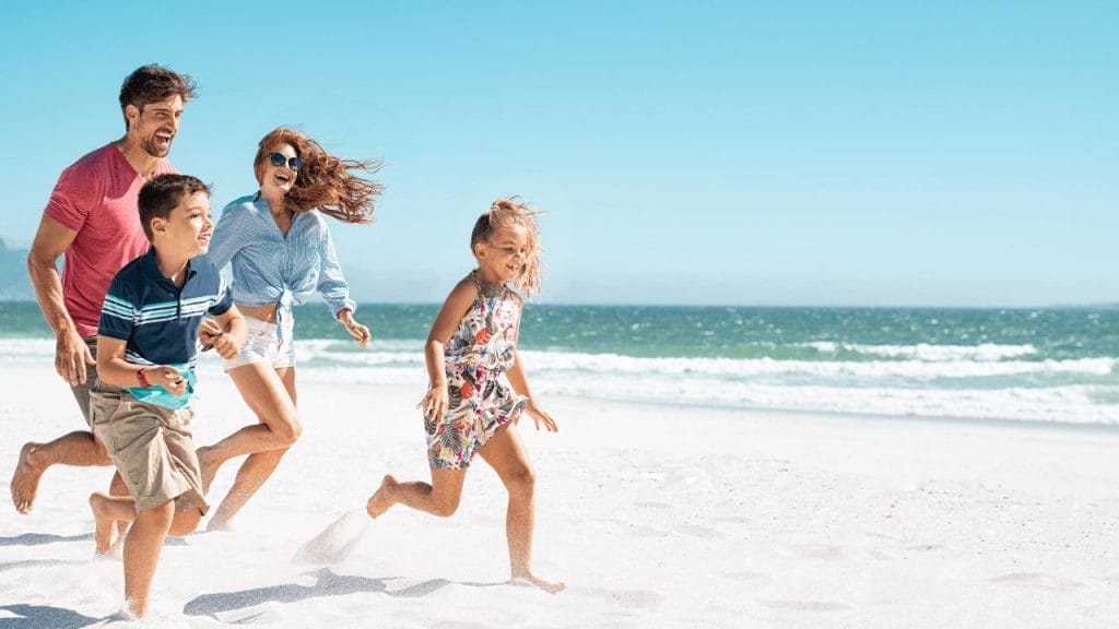 Family at the beach having fun together and parents supervise kids for to ensure beach safety for kids